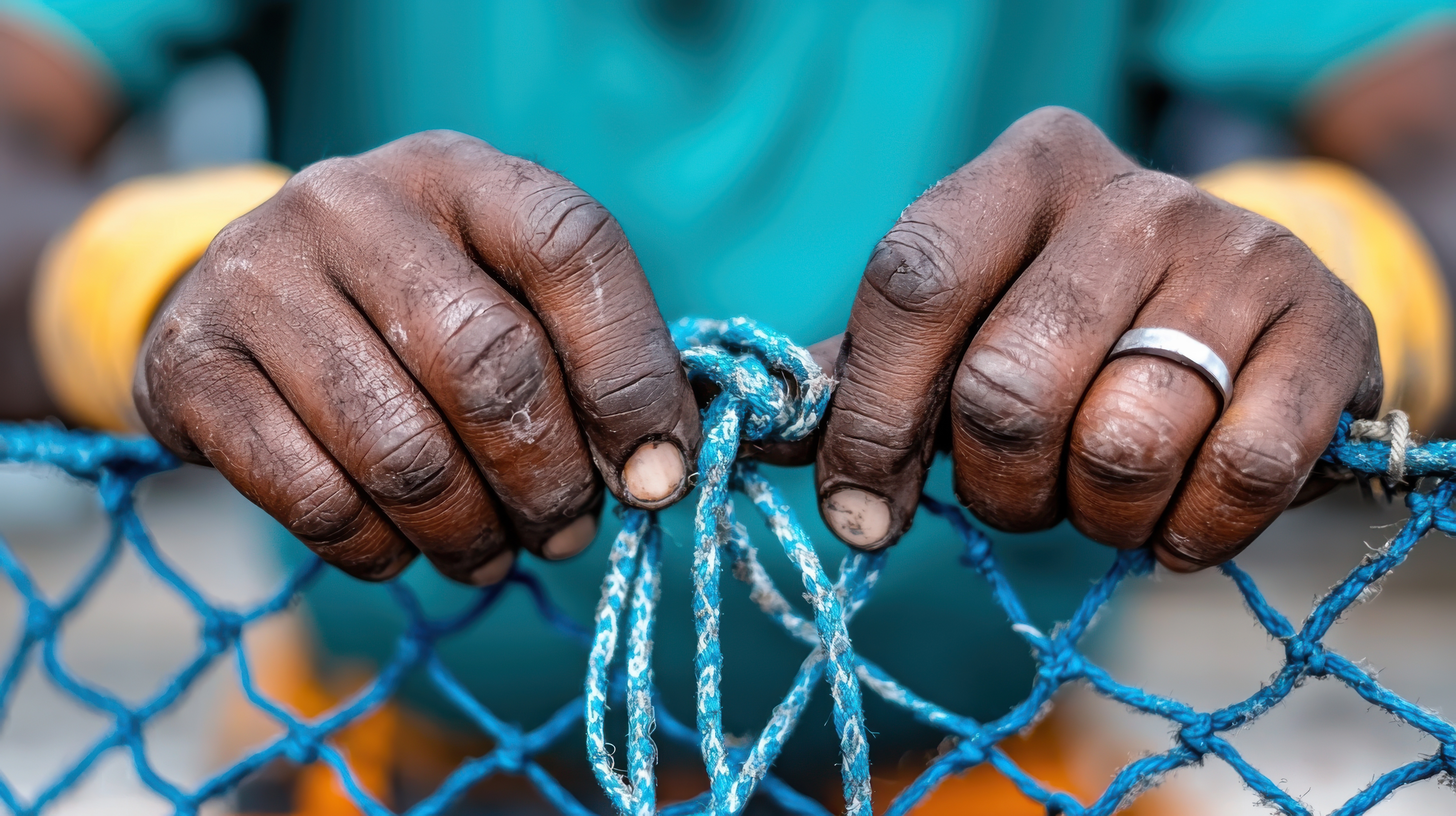 Fisherman’s hands holding and mending a net